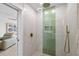 Modern bathroom with walk-in shower, rain shower head, and green tile accent wall at 4939 Floramar Ter # 902, New Port Richey, FL 34652