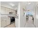 Bright kitchen with cream cabinets and stainless steel appliances flows into the living room at 4939 Floramar Ter # 902, New Port Richey, FL 34652