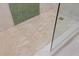 Glass shower featuring beige tile, a drain, and green tile accent at 4939 Floramar Ter # 902, New Port Richey, FL 34652