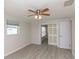 Bedroom featuring wood-look floors, a ceiling fan, and white sliding doors with access to another room at 5008 Forecastle Dr, New Port Richey, FL 34652