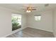 Bright bedroom with wood-look flooring, a ceiling fan, and large windows letting in natural light at 5008 Forecastle Dr, New Port Richey, FL 34652
