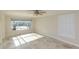 Sunlit bedroom with tile flooring, large window, and plantation shutters at 5008 Forecastle Dr, New Port Richey, FL 34652