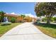 Beautiful front exterior featuring a well-manicured lawn, inviting driveway, and tropical landscaping at 5008 Forecastle Dr, New Port Richey, FL 34652