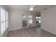 Living room featuring wood-look flooring, plantation shutters, and sliding doors to the pool area at 5008 Forecastle Dr, New Port Richey, FL 34652