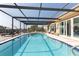 Outdoor pool with enclosure, covered patio and chairs for lounging at 5008 Forecastle Dr, New Port Richey, FL 34652