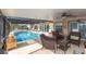 A covered patio with wicker furniture overlooking an in-ground swimming pool at 5008 Forecastle Dr, New Port Richey, FL 34652