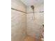 Walk-in shower features neutral tile, a handheld shower head, and accent tile at 5008 Forecastle Dr, New Port Richey, FL 34652