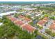 Aerial view showcases multi-unit residential complex, featuring landscaped grounds and community pond at 5041 Royal Palms Way # 203, New Port Richey, FL 34652