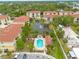 Aerial view of residential complex featuring community pool, lush landscaping, ponds, and parking areas at 5041 Royal Palms Way # 203, New Port Richey, FL 34652
