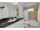 Well-lit bathroom featuring a black countertop vanity and shower-tub combination with shower curtain at 5041 Royal Palms Way # 203, New Port Richey, FL 34652