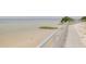 Peaceful beach view showcasing a railing path, seagull, and serene water at 5041 Royal Palms Way # 203, New Port Richey, FL 34652