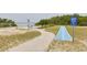 Beach access mat, providing easy access to a beautiful beach with lush vegetation and calm waters at 5041 Royal Palms Way # 203, New Port Richey, FL 34652