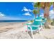 Tranquil beach scene with two Adirondack chairs under palm trees, offering a perfect spot to unwind at 5041 Royal Palms Way # 203, New Port Richey, FL 34652
