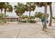 Picturesque beach entrance featuring palm trees, a restroom and a convenient dog waste station at 5041 Royal Palms Way # 203, New Port Richey, FL 34652