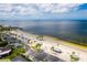 Scenic view of a beach with calm water, palm trees, and neighborhood homes in the background at 5041 Royal Palms Way # 203, New Port Richey, FL 34652