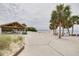 Scenic beach view with a shaded pavilion, picnic tables, and palm trees lining the sandy shore at 5041 Royal Palms Way # 203, New Port Richey, FL 34652