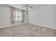 Cozy bedroom with carpeted floor, ceiling fan, and a window with tan curtains at 5041 Royal Palms Way # 203, New Port Richey, FL 34652