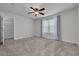 Spacious bedroom with neutral carpet, ceiling fan, and a walk-in closet for ample storage at 5041 Royal Palms Way # 203, New Port Richey, FL 34652