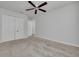 Bright bedroom with a ceiling fan, carpeted floor, and double closet doors at 5041 Royal Palms Way # 203, New Port Richey, FL 34652