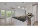 Modern kitchen area featuring a breakfast bar, stainless steel appliances, and adjacent light-filled living area at 5041 Royal Palms Way # 203, New Port Richey, FL 34652