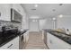 Stylish kitchen with white cabinetry, stainless steel appliances, black countertops, and open layout at 5041 Royal Palms Way # 203, New Port Richey, FL 34652