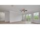 Open living room with modern light fixture, wood floors, and sliding glass doors to the balcony at 5041 Royal Palms Way # 203, New Port Richey, FL 34652