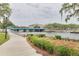 Scenic waterway with a pedestrian bridge, lush landscaping, and walking path creating a picturesque waterfront setting at 5041 Royal Palms Way # 203, New Port Richey, FL 34652