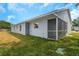View of home's backyard, side of house, manicured lawn and screened-in patio at 5214 Idlewild St, New Port Richey, FL 34653