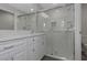 Bright, renovated bathroom features double vanity and a glass-enclosed shower with marble tiling at 5214 Idlewild St, New Port Richey, FL 34653