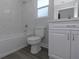 A modern bathroom featuring tile surround, grey walls, a toilet and vanity sink at 5214 Idlewild St, New Port Richey, FL 34653