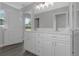 This bathroom features a double sink vanity, white cabinets, and a view to the exterior at 5214 Idlewild St, New Port Richey, FL 34653
