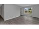 The bedroom has neutral walls and grey wood-look floors, along with a large window at 5214 Idlewild St, New Port Richey, FL 34653