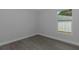 A bedroom featuring gray wood-look floors and a window with sky views at 5214 Idlewild St, New Port Richey, FL 34653