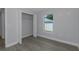 Bedroom features a closet with the door open, window with natural light, and luxury vinyl plank flooring at 5214 Idlewild St, New Port Richey, FL 34653