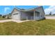 Charming single-story home featuring a two-car garage and covered front porch with white railing at 5214 Idlewild St, New Port Richey, FL 34653