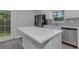 Bright kitchen featuring white cabinets, stainless steel appliances, and a gray tile backsplash at 5214 Idlewild St, New Port Richey, FL 34653