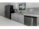 Bright kitchen features stainless steel appliances, white cabinets, and quartz countertops at 5214 Idlewild St, New Port Richey, FL 34653