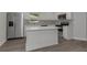 Bright kitchen featuring white cabinets, stainless steel appliances, and a center island with white countertops at 5214 Idlewild St, New Port Richey, FL 34653