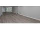 Open living room with gray wood floors and fresh paint throughout at 5214 Idlewild St, New Port Richey, FL 34653