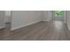 Spacious living room features gray wood floors, leading to a half bathroom at 5214 Idlewild St, New Port Richey, FL 34653