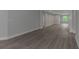 Open-concept living room featuring new gray wood floors, light gray walls, and bright lighting at 5214 Idlewild St, New Port Richey, FL 34653