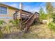 Backyard view with a raised wooden deck and stairs leading down to the yard at 5422 Foley Sq, New Port Richey, FL 34652