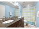 Bright bathroom with double sink vanity, a large mirror, and light blue walls at 5422 Foley Sq, New Port Richey, FL 34652