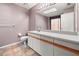 Well-lit bathroom featuring a white vanity with large mirror, a toilet, and colorful tile flooring at 5422 Foley Sq, New Port Richey, FL 34652