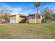 Inviting exterior of a yellow two-story home with a metal roof, attached garage, and a well-maintained front yard at 5422 Foley Sq, New Port Richey, FL 34652