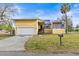 Inviting exterior of a yellow two-story home with a metal roof, attached garage, and a well-maintained front yard at 5422 Foley Sq, New Port Richey, FL 34652