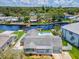 Aerial view of a waterfront home with a backyard pool, direct canal access, and a well-manicured lawn at 5512 Tropic Dr, New Port Richey, FL 34653