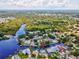 Aerial view of waterfront property with direct canal access, a private pool, and lush green surroundings at 5512 Tropic Dr, New Port Richey, FL 34653