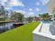 This backyard features a dock with canal access, a pool, and manicured artificial turf for low maintenance enjoyment at 5512 Tropic Dr, New Port Richey, FL 34653