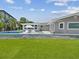 Backyard featuring a pool, outdoor furniture, a landscaped lawn, and a modern house design at 5512 Tropic Dr, New Port Richey, FL 34653